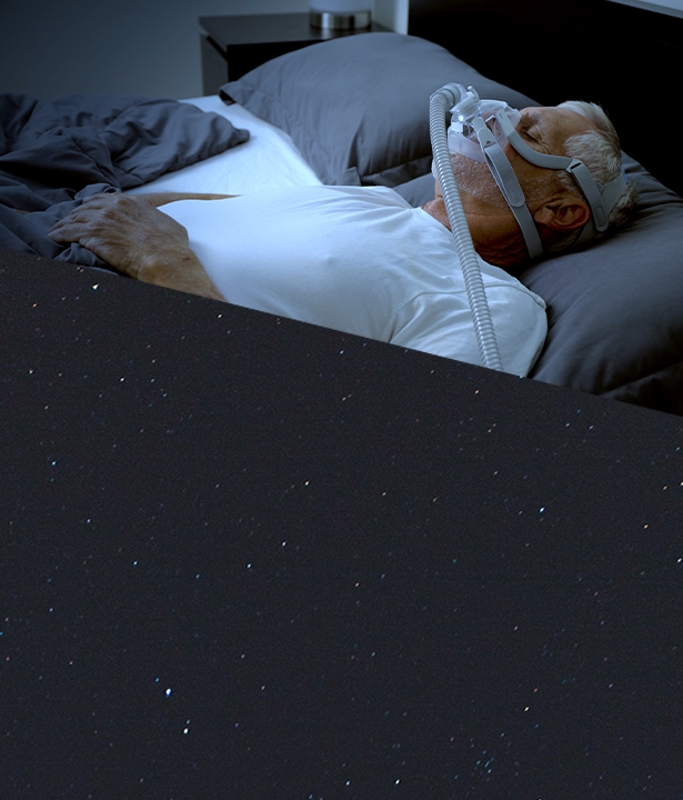 Man sleeping in bed, wearing a sleep apnea mask
